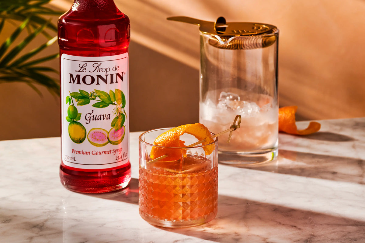 Monin Guava Syrup with a tropical guava cocktail and orange peel garnish
