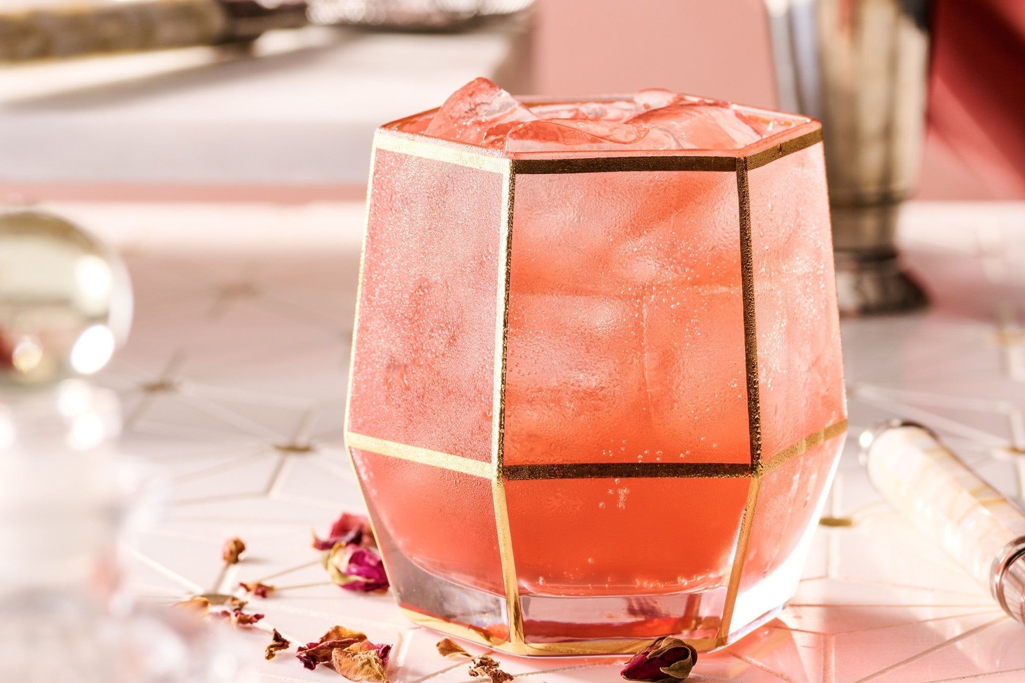Floral Valentine’s drink with strawberry and rose, served as a light pink sparkling spritz with garnish of dried rose petals.