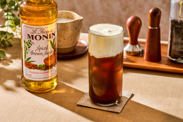 Iced cold brew topped with sugar-free spiced brown sugar cold foam made with Monin Spiced Brown Sugar Syrup.