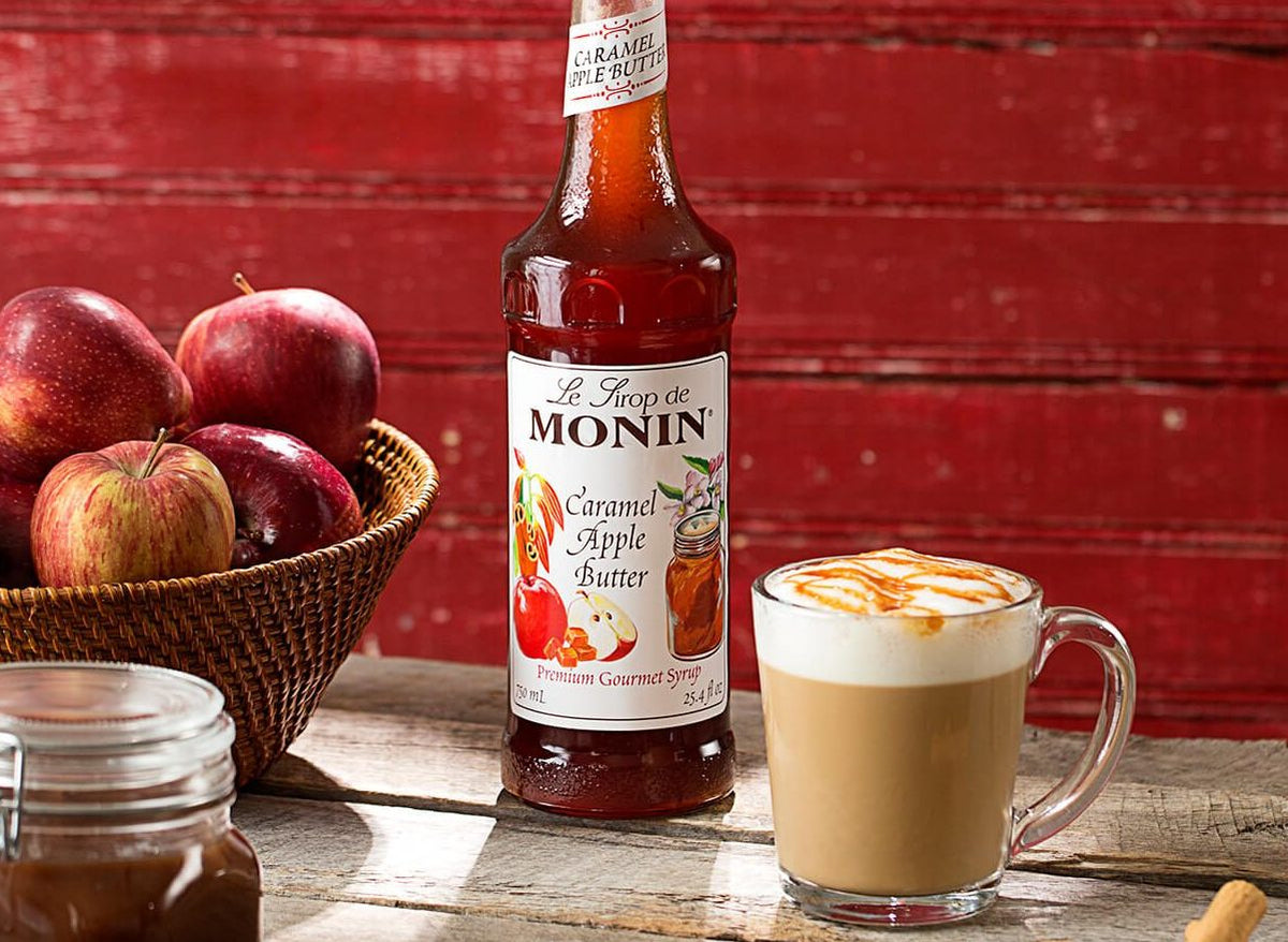 Monin Caramel Apple Butter Syrup with caramel apple latte, fresh apples and an apple jar