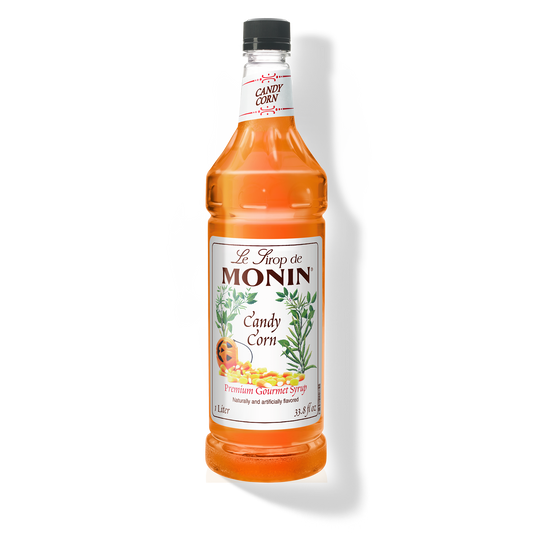 A bottle of Monin Candy Corn Syrup with a label showing the product name and an image of candy corn.