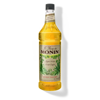 A bottle of Monin Organic Agave Natural Syrup filled with golden yellow liquid, featuring a cream-colored label with green agave plant illustrations and a black cap.