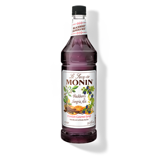 A bottle of Monin Blackberry Sangria Mix with a label showing a picture of blackberries and text indicating the flavor.