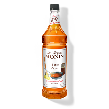 A 1L-bottle of Monin Brown Butter Syrup with a label showing the product name and the flavour