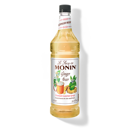 A bottle of Monin Ginger Beer Syrup with a label showing the brand name and the flavor, placed against a white background.