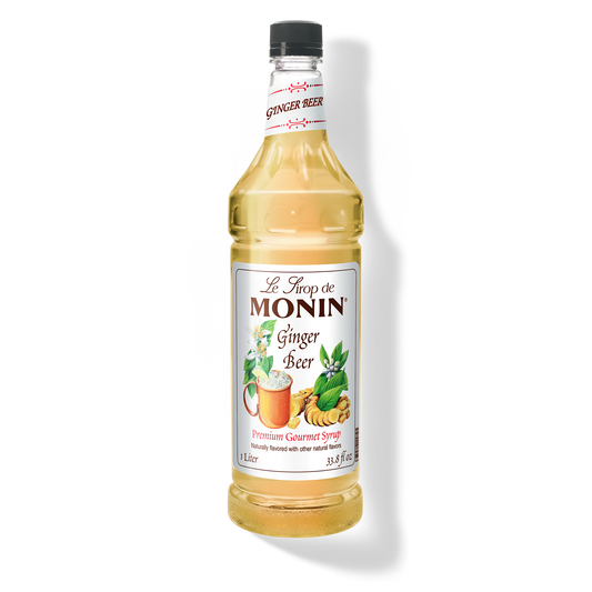 A bottle of Monin Ginger Beer Syrup with a label showing the brand name and the flavor, placed against a white background.