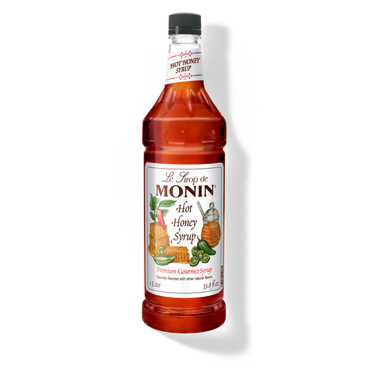 A bottle of Monin Hot Honey Syrup with a label showing the brand name and the flavor, placed against a white background.