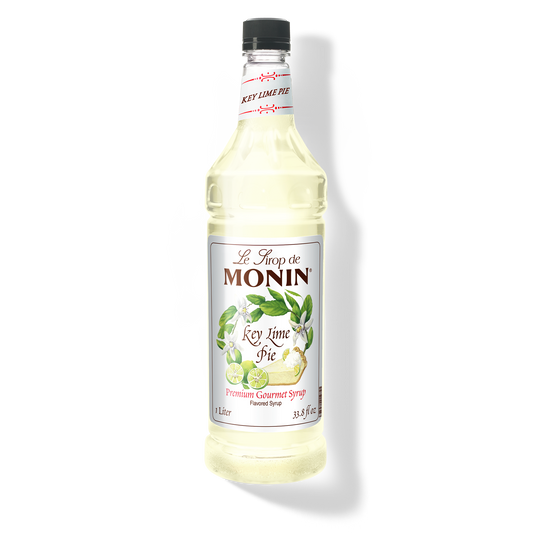 A bottle of Monin Key Lime Pie Syrup with a label showing the brand name and the flavor, placed against a white background.