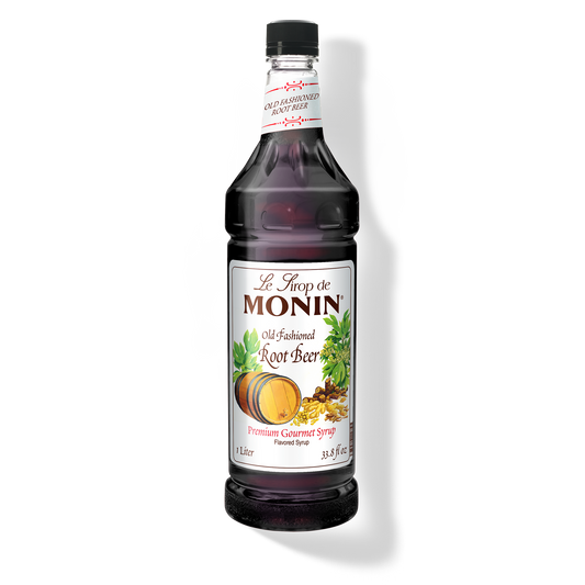 A bottle of Monin Old Fashioned Root Beer Syrup with a label showing the brand name and the flavor, placed against a white background.
