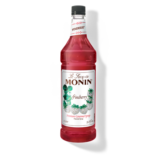 A bottle of Monin Pineberry Syrup with a label showing the brand name and the flavor, placed against a white background.