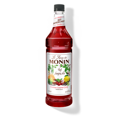 A bottle of Monin Red Sandria Mix Syrup with a label showing the brand name and the flavor, placed against a white background.
