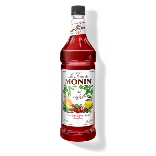 A bottle of Monin Red Sandria Mix Syrup with a label showing the brand name and the flavor, placed against a white background.
