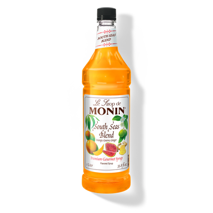 A bottle of Monin South Seas Blend Syrup with a label showing the brand name and the flavor, placed against a white background.
