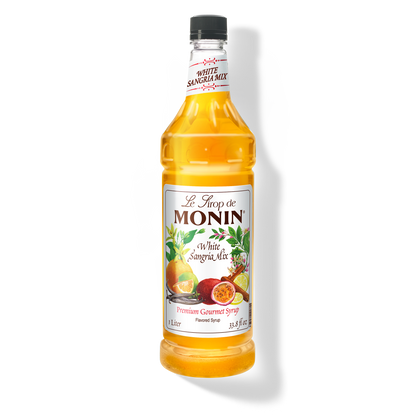 A bottle of Monin White Sangria Mix Syrup with a label showing the brand name and the flavor, placed against a white background.
