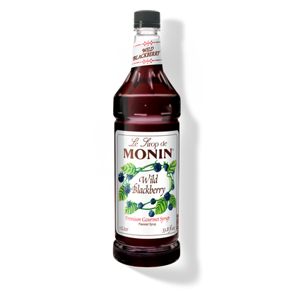 A bottle of Monin Wild Blackberry Syrup with a label showing the product name and a picture of blackberries.