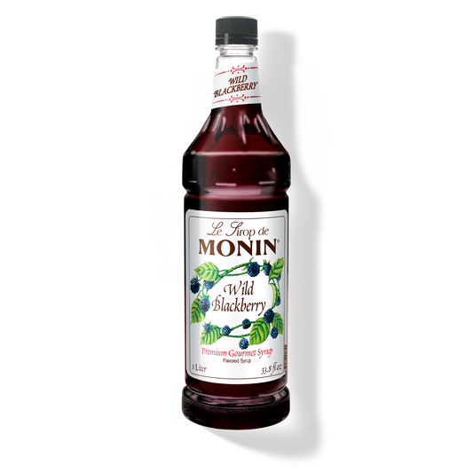 A bottle of Monin Wild Blackberry Syrup with a label showing the product name and a picture of blackberries.