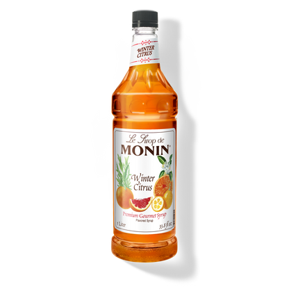 A bottle of Monin Winter Citrus Syrup with a label showing the brand name and the flavor, placed against a white background.