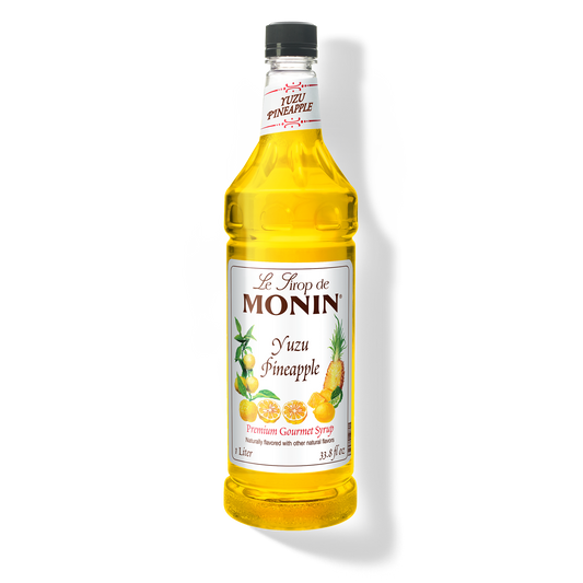 A bottle of Monin Yuzu Pineapple Syrup with a yellow liquid