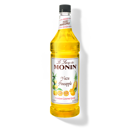 A bottle of Monin Yuzu Pineapple Syrup with a yellow liquid