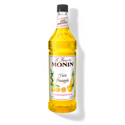A bottle of Monin Yuzu Pineapple Syrup with a yellow liquid