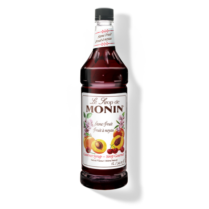 A 1L-bottle of Monin Stone Fruit Syrup with a label showing the brand name and the flavor, placed against a white background.