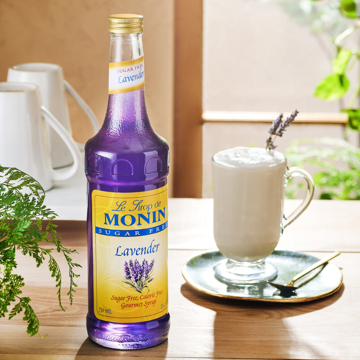 Monin Sugar Free Lavender Syrup beside a creamy lavender latte garnished with lavender