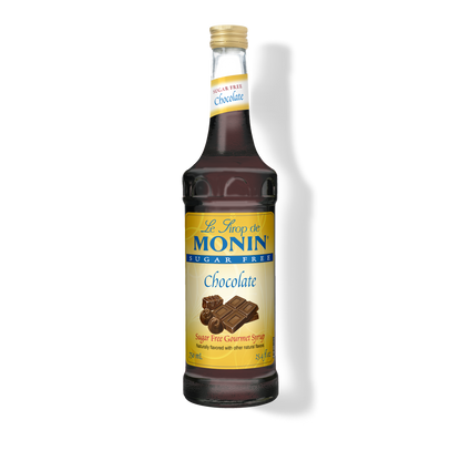 A bottle of Monin Sugar Free Chocolate Syrup, with a label showing the brand name and the product name, placed against a plain background.