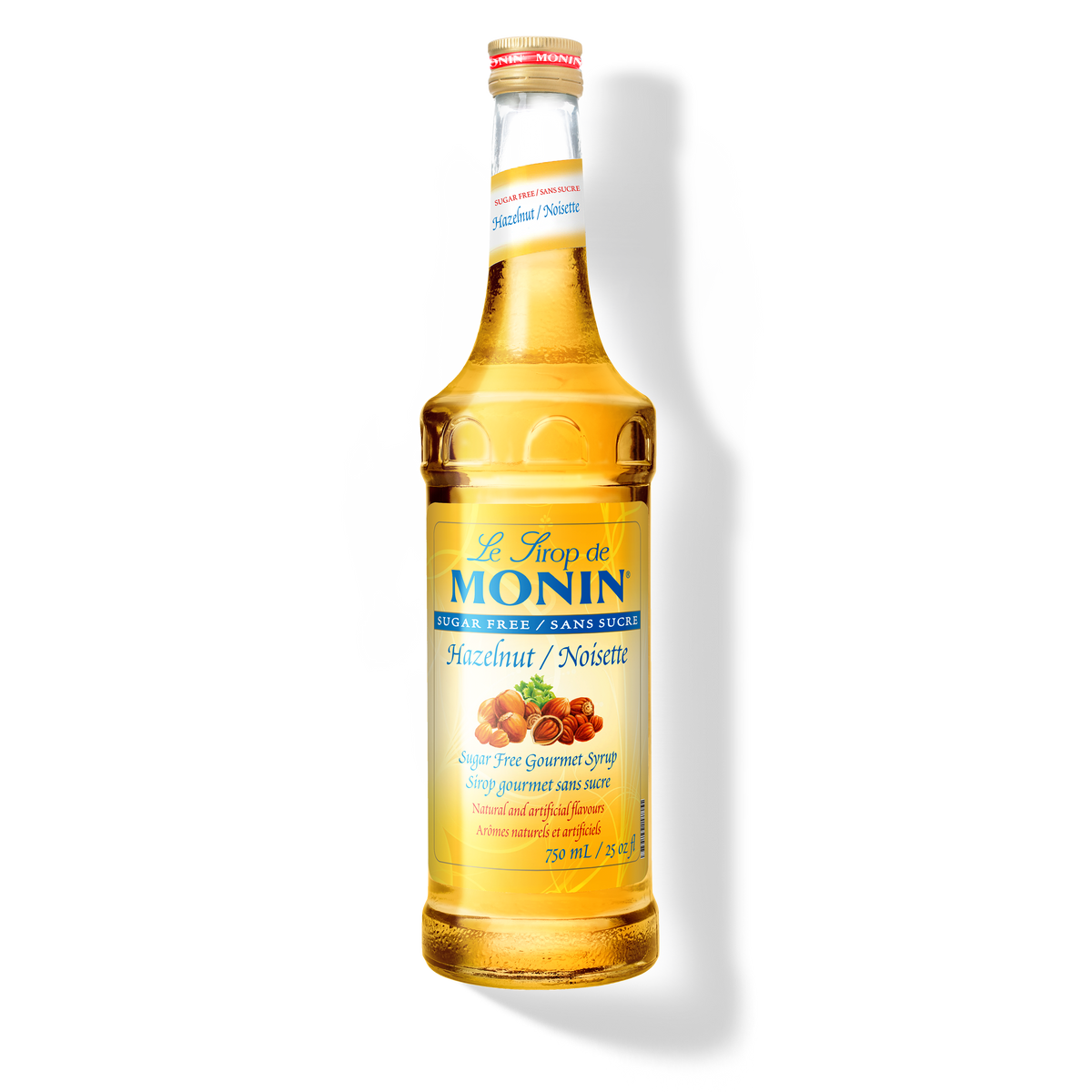 A glass bottle of Monin Sugar Free Hazelnut Syrup, with a yellow label displaying the product name and an image of hazelnuts.