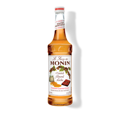A bottle of Monin Toasted Almond Mocha Syrup with a label showing the brand name and the flavor, placed against a white background.

