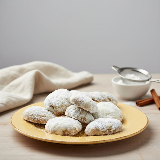Powdered sugar cookies made with Monin Maple Spice Syrup, served on a plate for a soft, warmly spiced maple-flavoured treat perfect for fall baking.