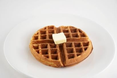 Waffle with a pat of butter on a white plate