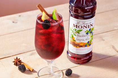 Monin Blackberry Sangria Mix with iced blackberry sangria, lime, berries and cinnamon garnish