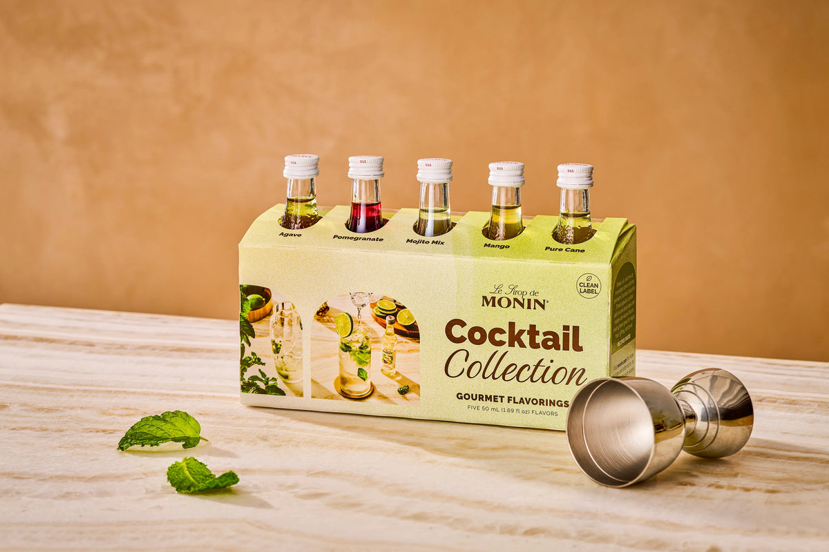Monin Cocktail Collection sample pack with five mini bottles, mint leaves and cocktail jigger