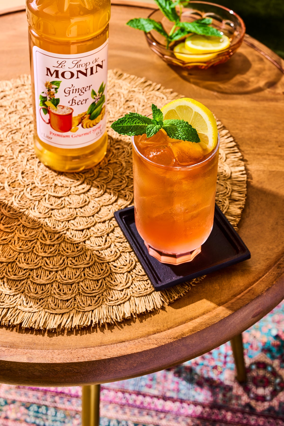Monin Ginger Beer Syrup with an iced ginger drink, lemon slice and fresh mint