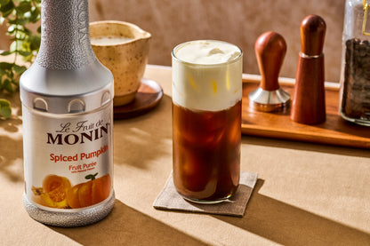 Monin Spiced Pumpkin Purée paired with an iced fall coffee topped with creamy cold foam, highlighting rich pumpkin flavour for seasonal beverages.