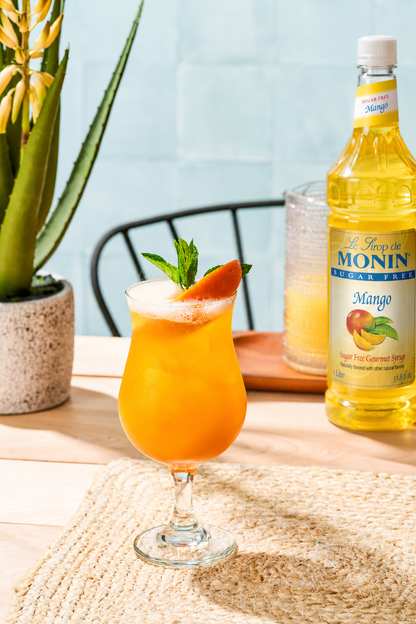 Monin Sugar Free Mango Syrup with a tropical mango mocktail and fresh mango garnish